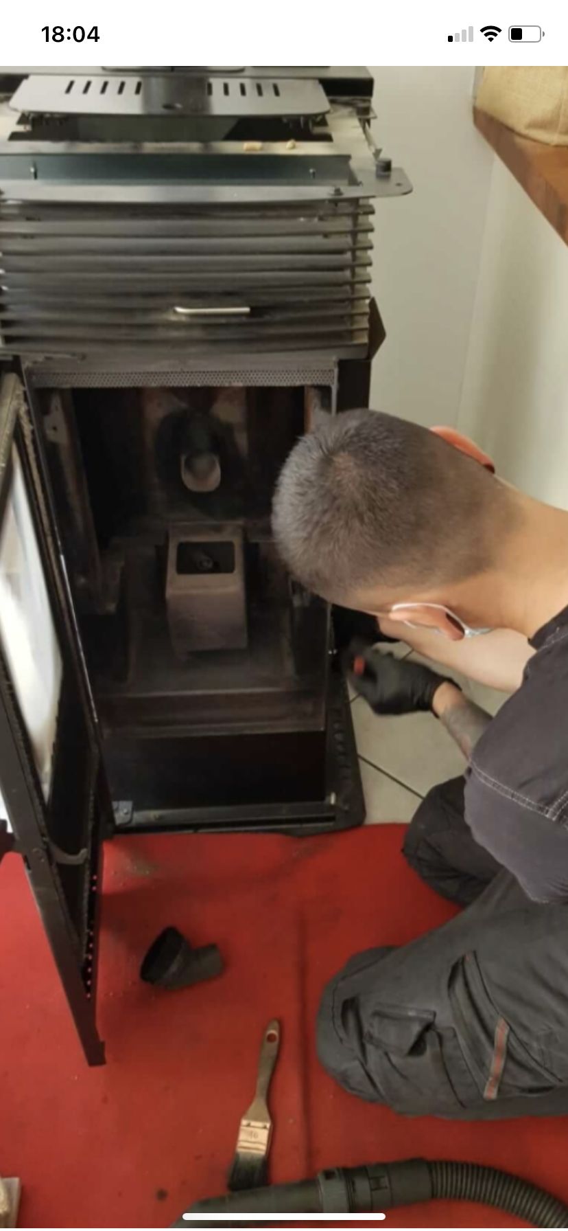 Technicien en cours d'entretien d'un poêle à granulés