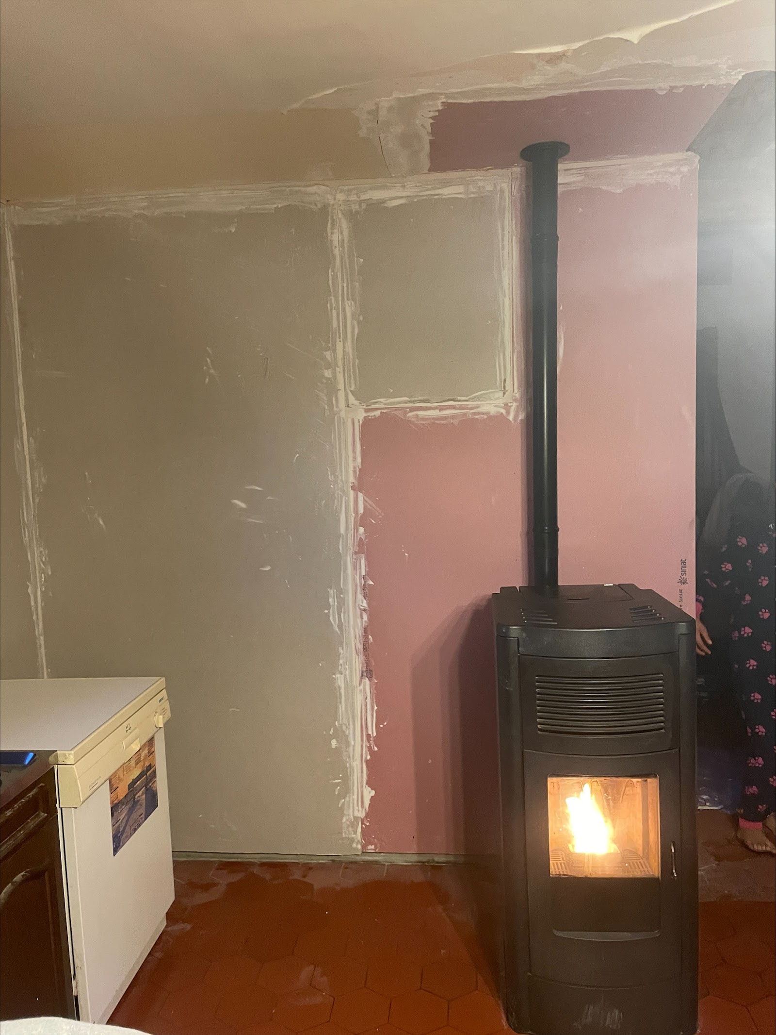 Poêle à granulés installé et allumé dans un salon en rénovation